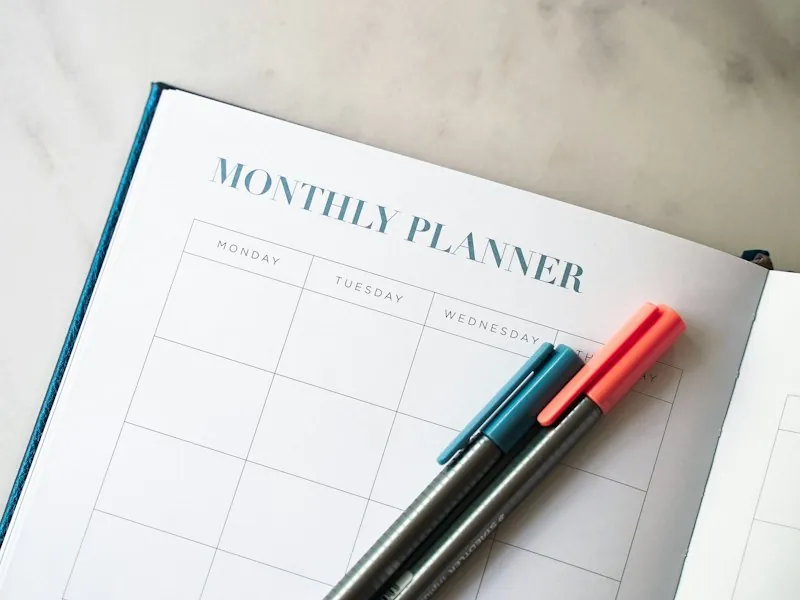 Planner notebook with two pens on a desk