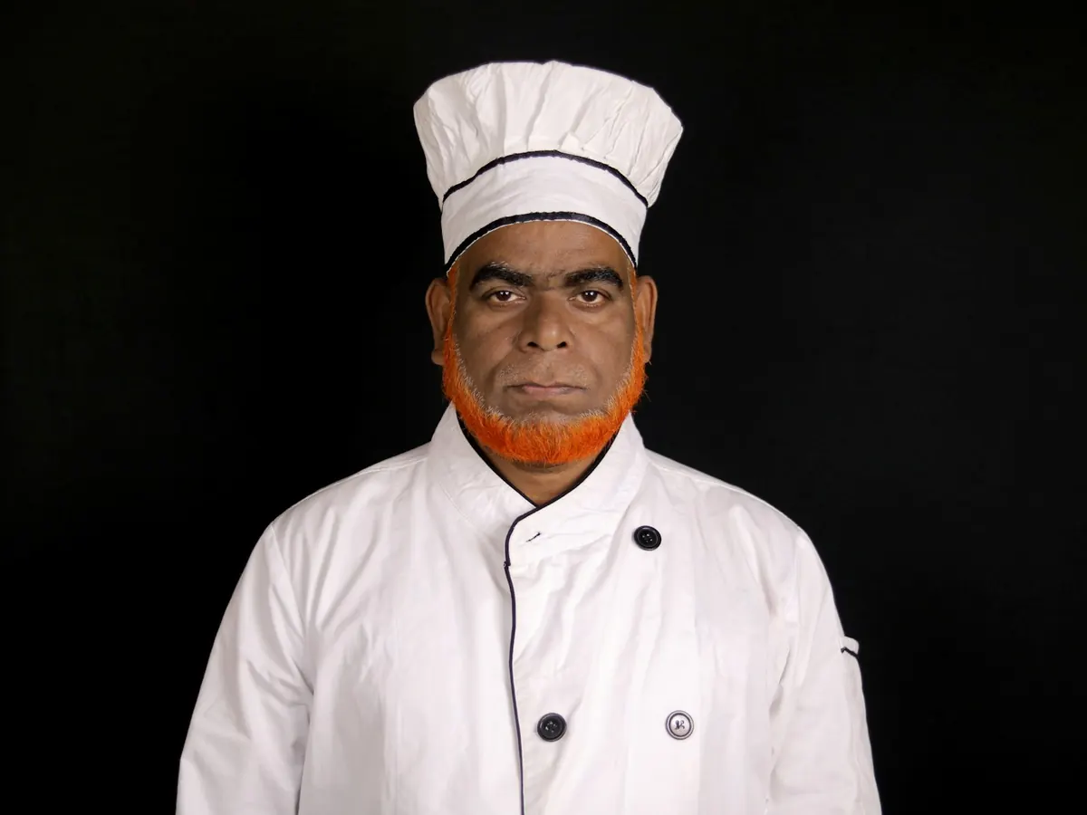 Chef in a white double-breasted coat and tall white hat