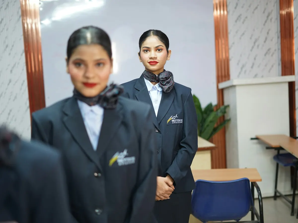 Two receptionists in navy blazers with neck scarves